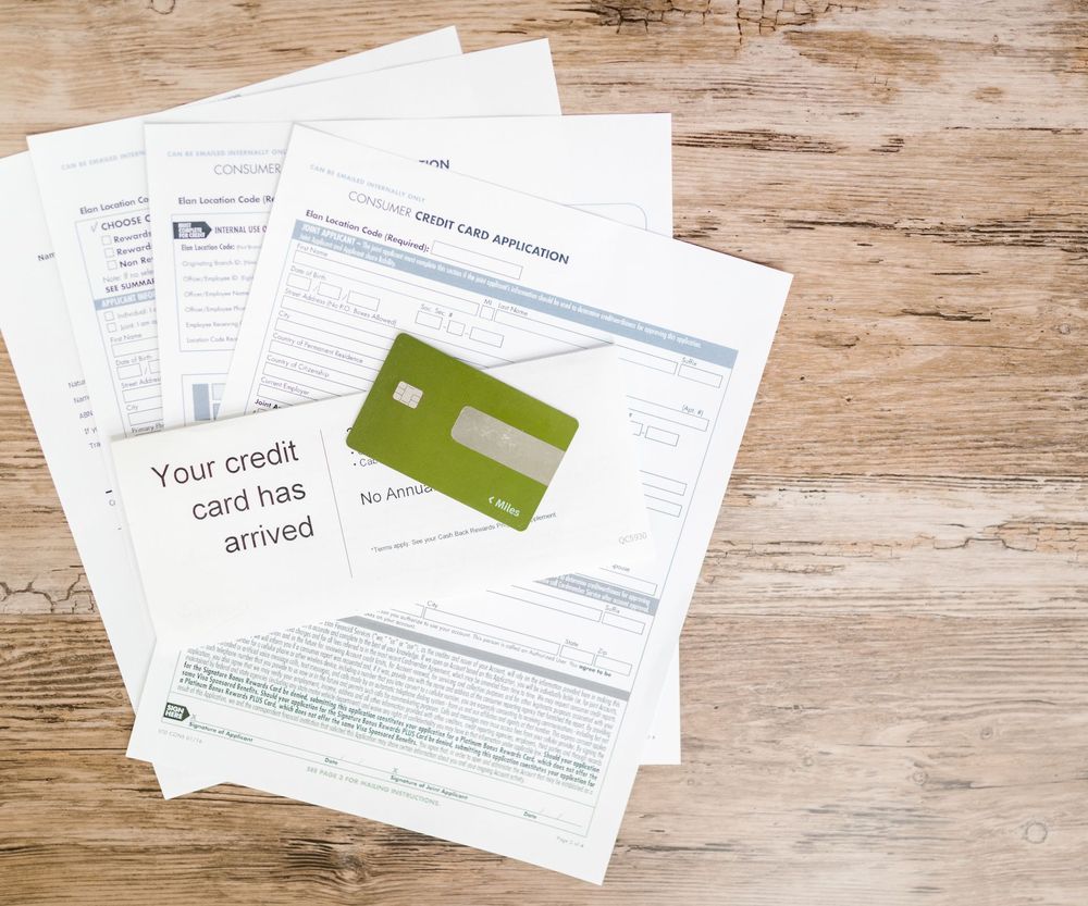 Solicitud de tarjeta de crédito y cartas del banco sobre un escritorio