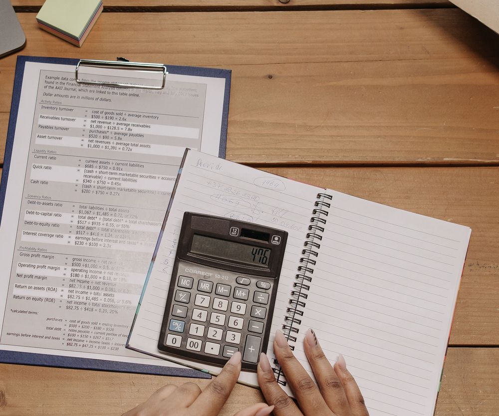 Reporte financiero, libreta y calculadora sobre un escritorio durante la preparación de taxes